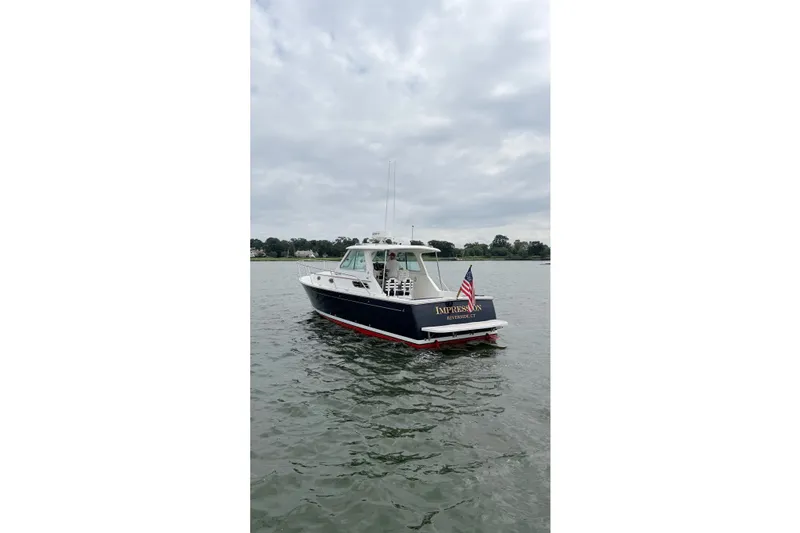 Slide: The Image of 2006 Back Cove 29 boat on water, displaying American flag, overcast sky. - 5
