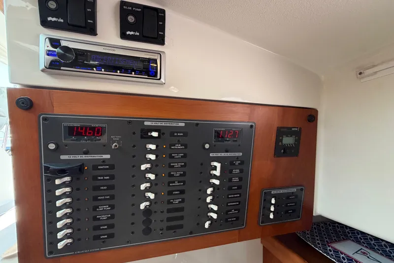 Slide: The Image of Electrical panel of a 2006 Back Cove 29 boat with control switches and displays. - 32