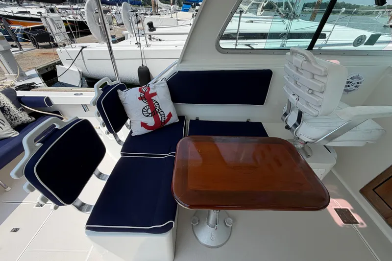 Slide: The Image of Interior of a 2006 Back Cove 29 boat with navy seating and wooden table. - 47