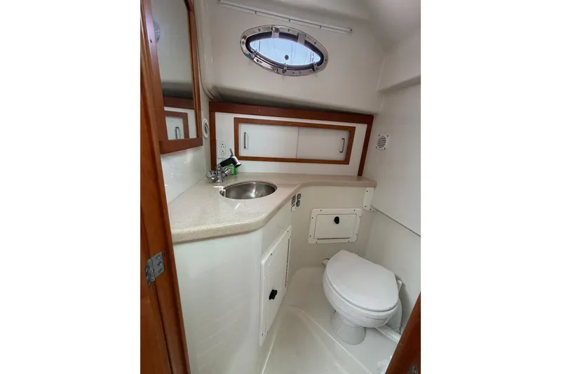 Slide: The Image of 2006 Back Cove 29 boat bathroom with sink, toilet, and storage cabinets. - 33
