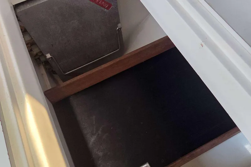 Slide: The Image of Storage compartment inside a 1994 J Boats J/130 sailboat, featuring a wooden divider. - 45