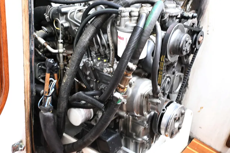 Slide: The Image of Engine compartment of a 1994 J Boats J/130 sailboat, showcasing mechanical components and wiring. - 52