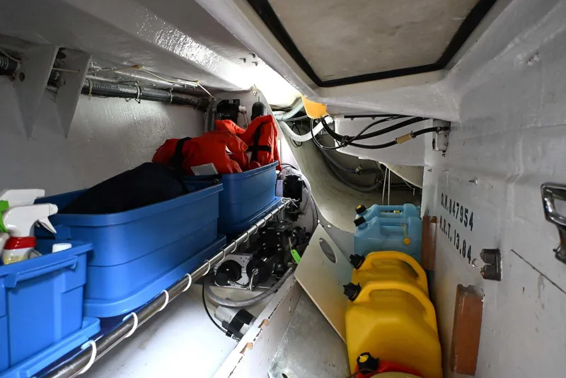 Slide: The Image of Storage area inside a 1994 J Boats J/130, featuring blue bins and yellow fuel containers. - 34