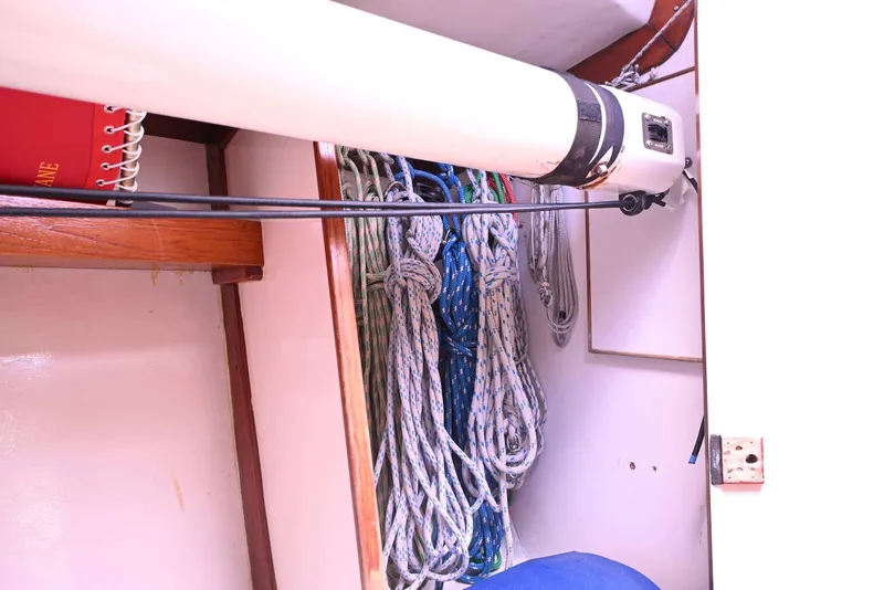 Slide: The Image of Interior view of a 1994 J Boats J/130 sailboat, featuring neatly coiled ropes and wooden shelving. - 39