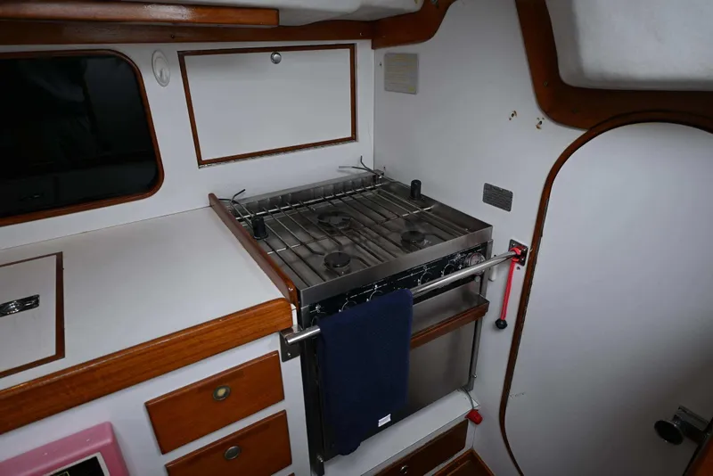 Slide: The Image of Interior of a 1994 J Boats J/130 yacht featuring a compact kitchen with stove. - 43