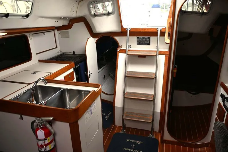 Slide: The Image of Interior of 1994 J Boats J/130 sailboat with kitchen and wooden stairs. - 32
