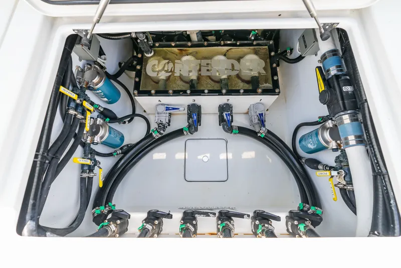 Slide: The Image of A view inside the engine compartment of a 2023 Contender 44 ST with various hoses and valves. - 36