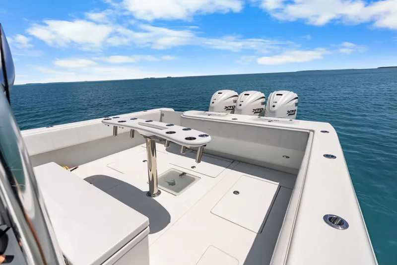Slide: The Image of The image shows a 2023 Contender 44 ST boat on open water with four outboard engines. - 30