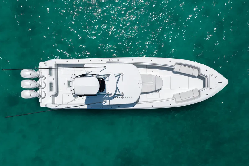 Slide: The Image of Aerial view of a white 2023 Contender 44 ST boat on turquoise water. - 37