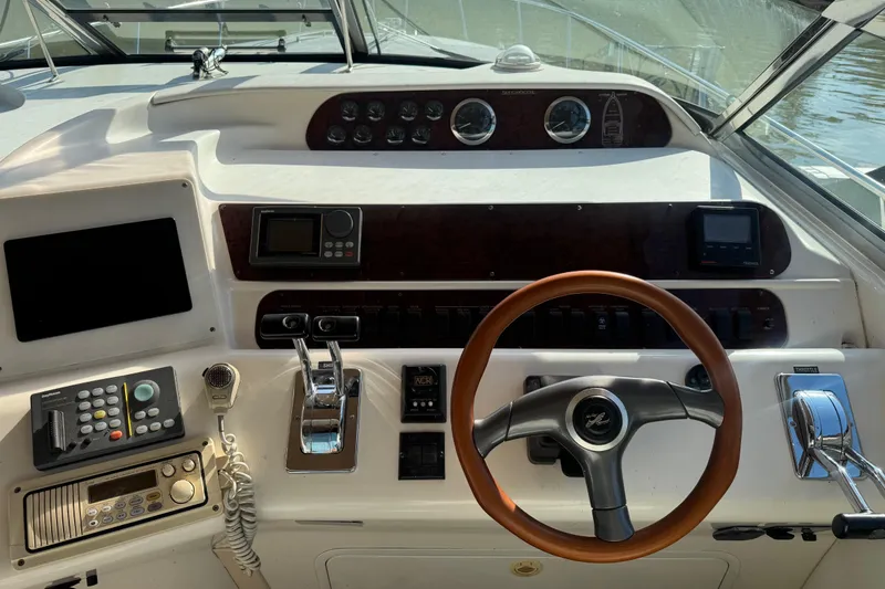 Slide: The Image of Cockpit of 1996 Sea Ray 450 Sundancer with steering wheel and control panel. - 10
