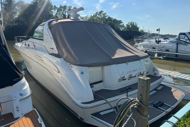 Slide: The Image of 1996 Sea Ray 450 Sundancer yacht docked, featuring sleek design and covered deck. - 0