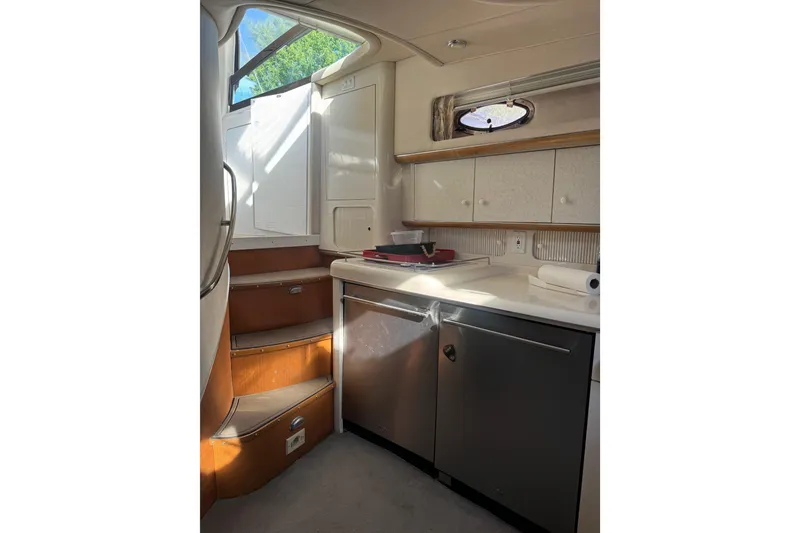 Slide: The Image of Interior of 1996 Sea Ray 450 Sundancer yacht, featuring a compact kitchen area. - 14