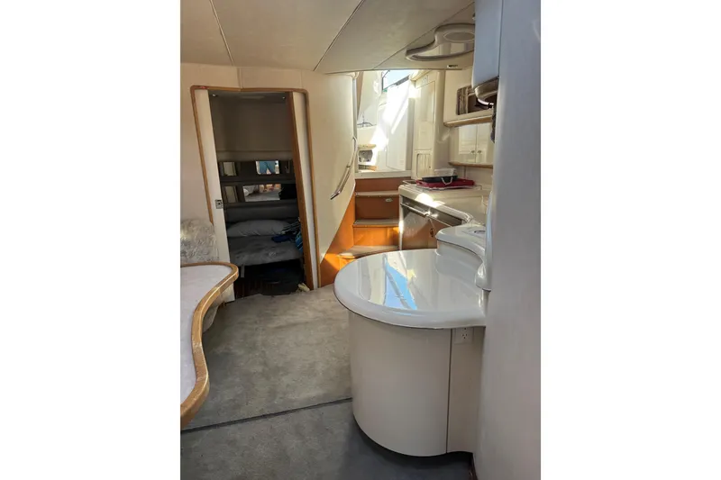 Slide: The Image of Interior of 1996 Sea Ray 450 Sundancer yacht, featuring kitchen and cozy sleeping area. - 20