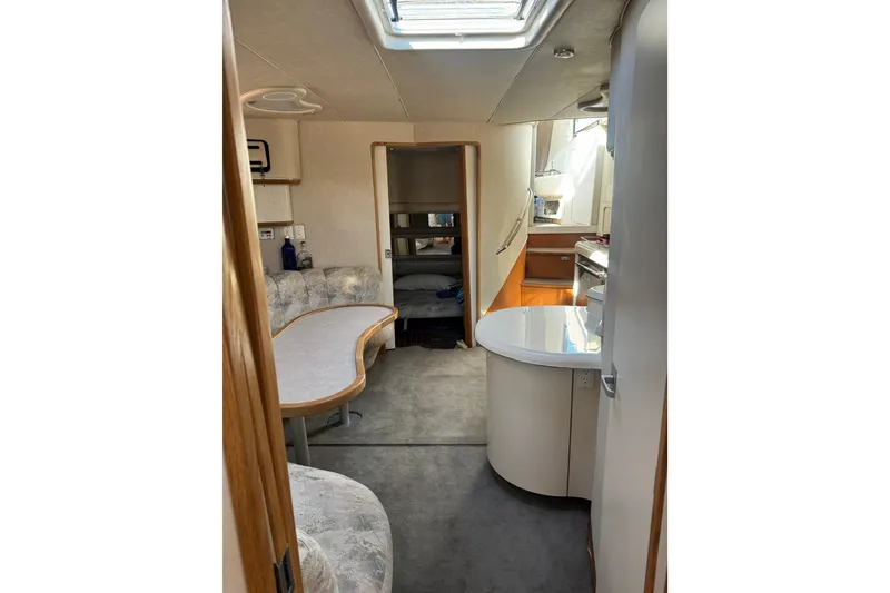 Slide: The Image of Interior of 1996 Sea Ray 450 Sundancer yacht, featuring cozy seating and modern amenities. - 24