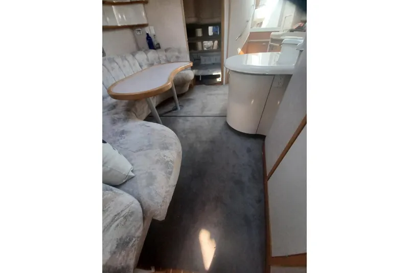 Slide: The Image of Interior of 1996 Sea Ray 450 Sundancer yacht with plush seating and dining area. - 18