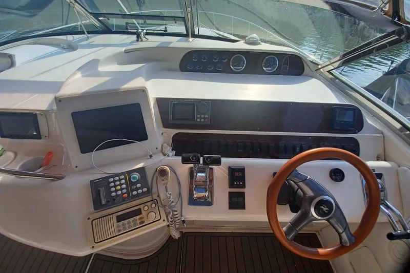 Slide: The Image of 1996 Sea Ray 450 Sundancer helm with steering wheel, navigation controls, and dashboard instruments. - 9