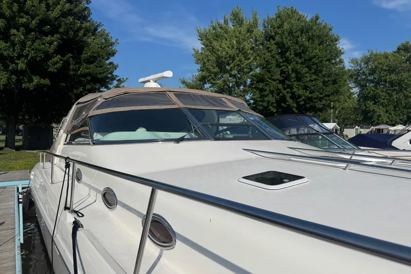 Slide: The Image of 1996 Sea Ray 450 Sundancer yacht docked, featuring sleek design and spacious deck. - 6