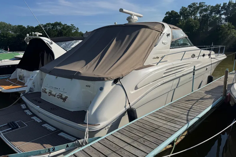 The Image of 1996 Sea Ray 450 Sundancer docked, covered, with "The Good Stuff" on the stern. - 3