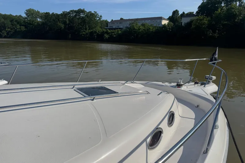 Slide: The Image of 1996 Sea Ray 450 Sundancer yacht on calm river with lush green shoreline. - 7