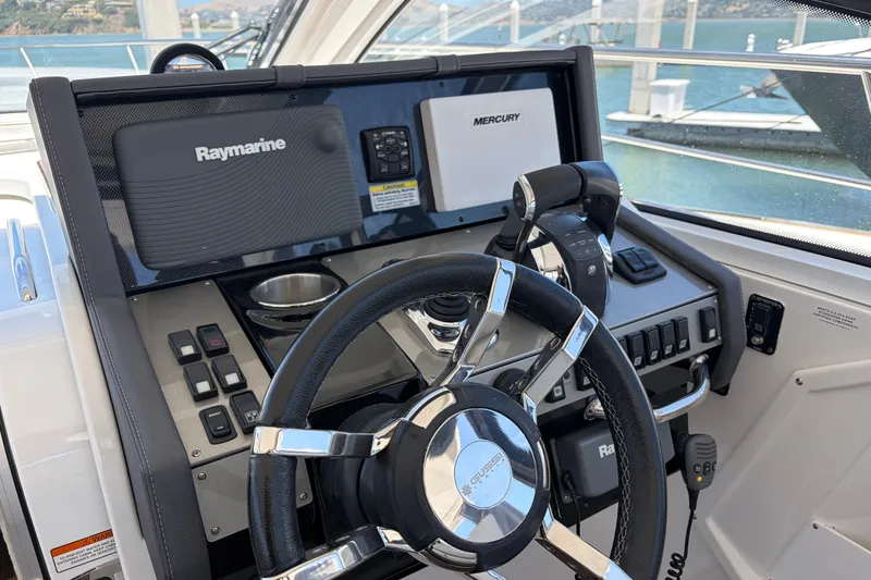 Slide: The Image of Helm of 2015 Cruisers 390 yacht with Raymarine and Mercury controls, docked by the water. - 7