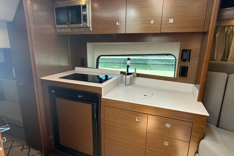 Slide: The Image of Modern kitchen area in a 2015 Cruisers 390 yacht with stove, sink, and microwave. - 10