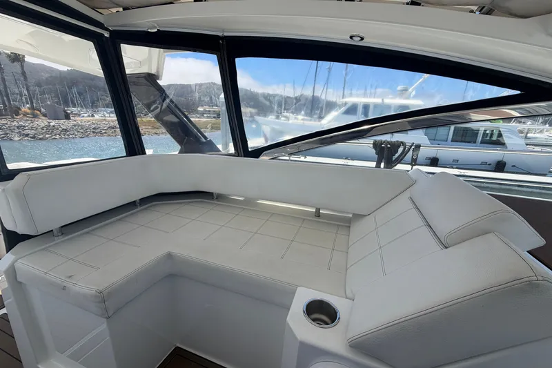 Slide: The Image of Interior view of 2015 Cruisers 390 yacht with white seating and marina backdrop. - 6