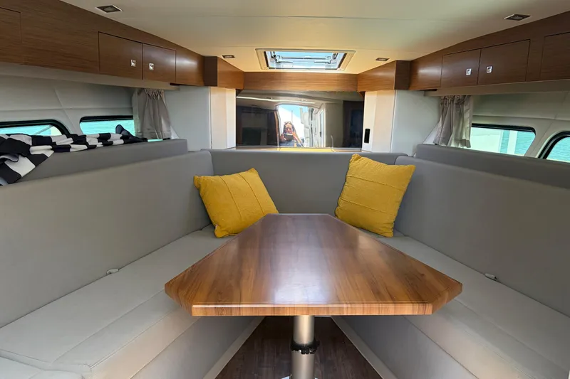 Slide: The Image of Interior of 2015 Cruisers 390 yacht with wooden table and gray seating. - 8