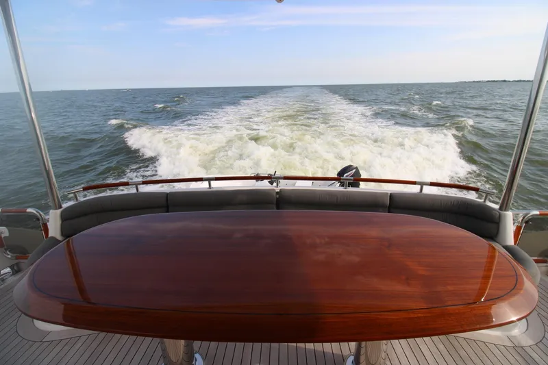 Slide: The Image of Luxurious 2007 Lazzara 74 Motoryacht cruising, featuring elegant wooden table and ocean view. - 7