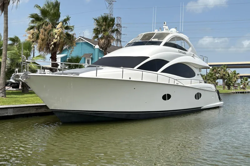 The Image of 2007 Lazzara 74 Motoryacht docked by palm trees under a clear blue sky. - 1