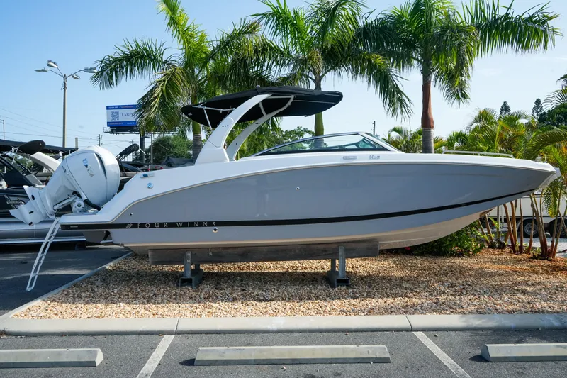 The Image of 2027 Four Winns HD8 OB boat displayed outdoors with palm trees in the background. - 1