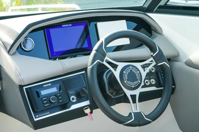 Slide: The Image of 2027 Four Winns HD8 OB boat dashboard with steering wheel and navigation display. - 16