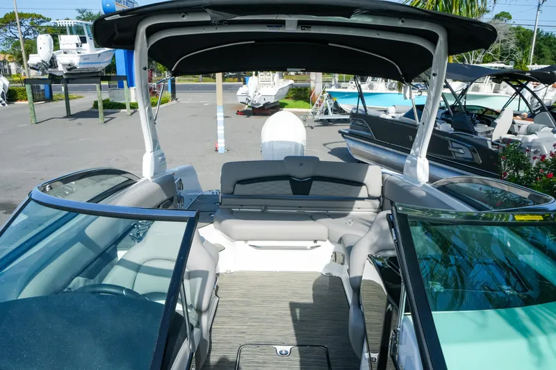 Slide: The Image of 2027 Four Winns HD8 OB boat interior with seating and canopy in a marina setting. - 29