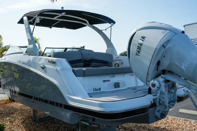 Slide: The Image of 2027 Four Winns HD8 OB boat with Yamaha outboard motor, docked on gravel. - 7