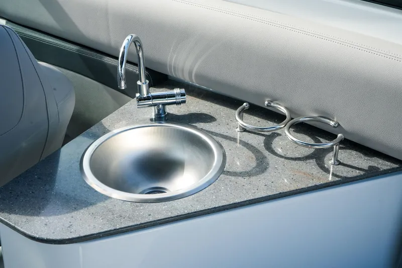 Slide: The Image of 2027 Four Winns HD8 OB boat sink with stainless steel faucet and cup holders. - 17