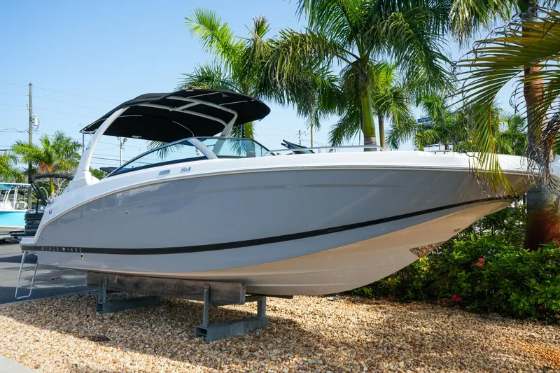 Slide: The Image of 2027 Four Winns HD8 OB boat displayed outdoors with palm trees in the background. - 2