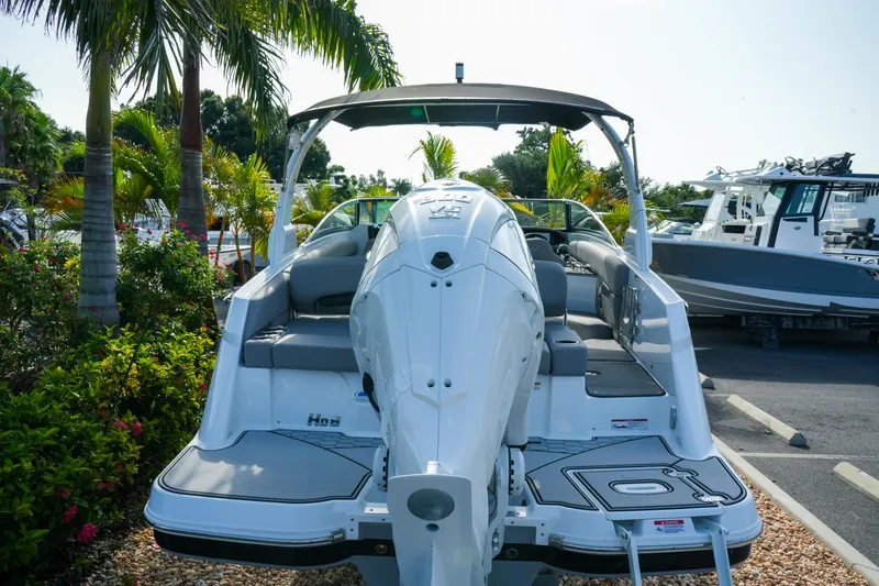 Slide: The Image of 2027 Four Winns HD8 OB boat with outboard motor, parked near tropical palm trees. - 6