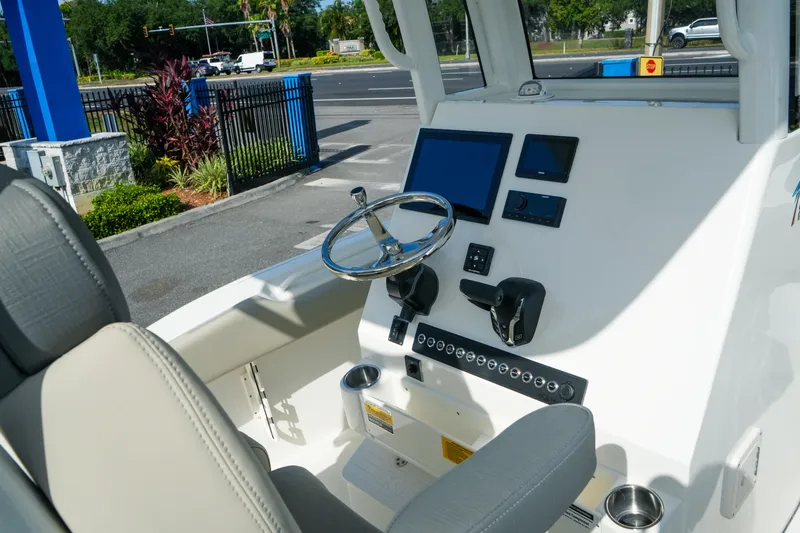 Slide: The Image of 2027 Key West 249 FS boat cockpit with steering wheel and control panel. - 26