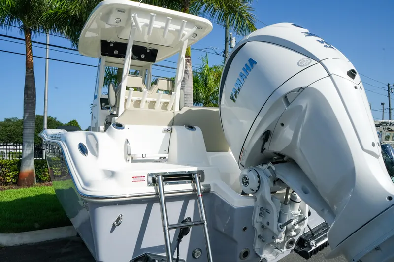 Slide: The Image of 2027 Key West 249 FS boat with Yamaha engine, parked near palm trees. - 14