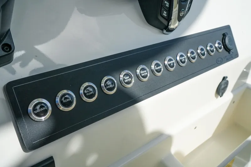 Slide: The Image of Control panel of 2027 Key West 249 FS boat with labeled buttons and switches. - 28