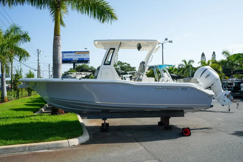 The Image of 2027 Key West 249 FS boat displayed outdoors with palm trees and clear sky. - 1