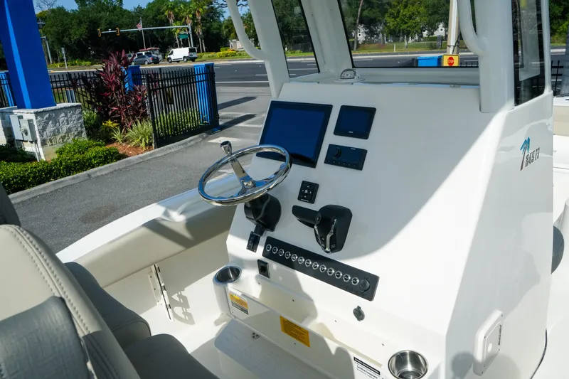 Slide: The Image of 2027 Key West 249 FS boat dashboard with steering wheel and electronic controls. - 25