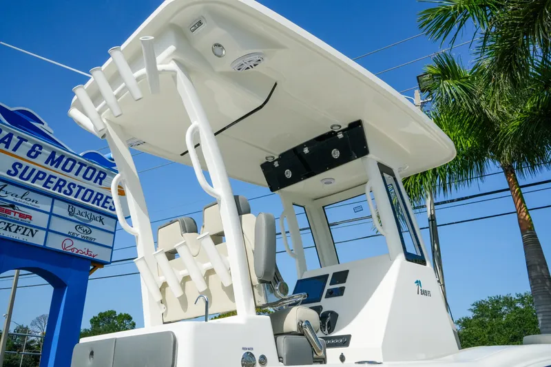 Slide: The Image of 2027 Key West 249 FS boat at dealership, showcasing helm and seating under clear blue sky. - 9
