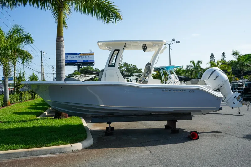Slide: The Image of 2027 Key West 249 FS boat displayed outdoors with palm trees and clear sky. - 2