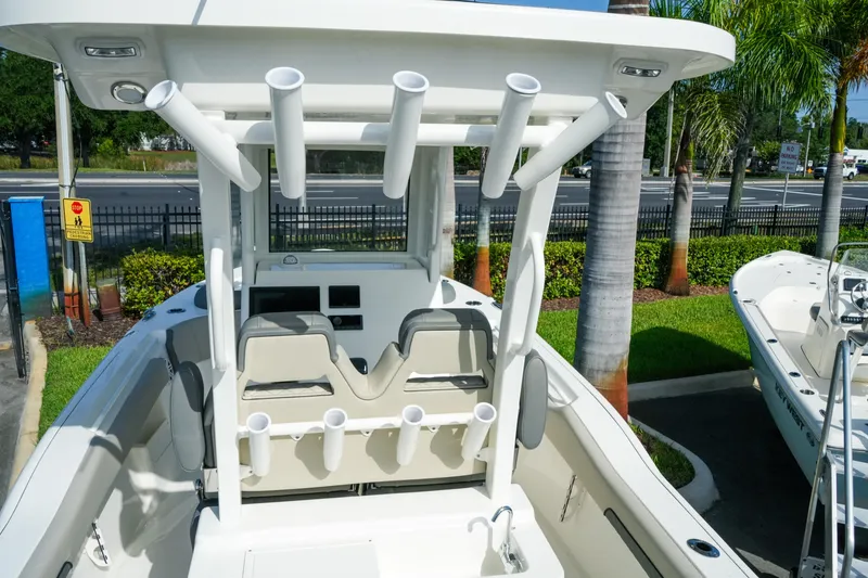 Slide: The Image of 2027 Key West 249 FS boat interior with rod holders and seating, parked outdoors. - 18