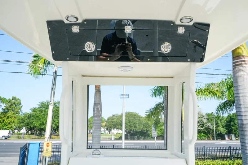 Slide: The Image of 2027 Key West 249 FS boat console with storage compartment, surrounded by palm trees. - 24