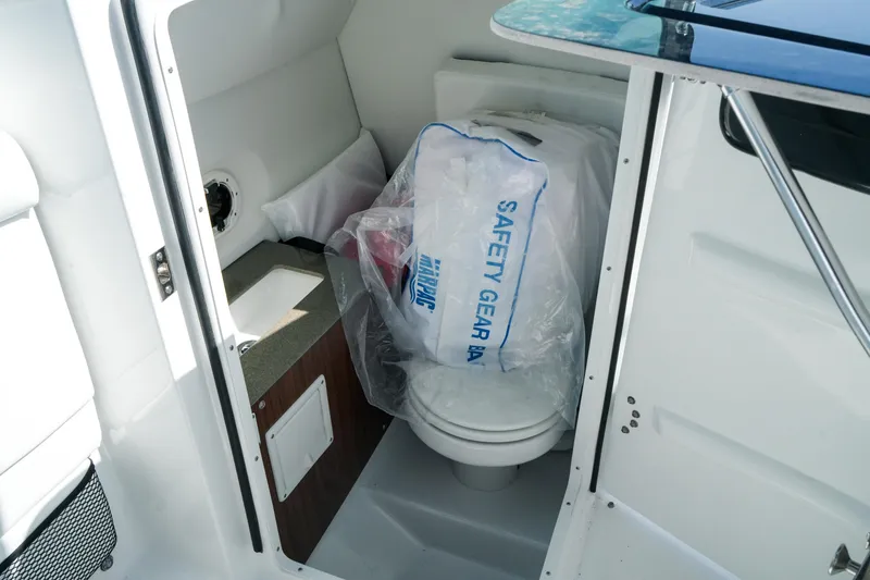 Slide: The Image of Interior of 2026 Four Winns HD8 OB boat with safety gear bag and compact toilet. - 26