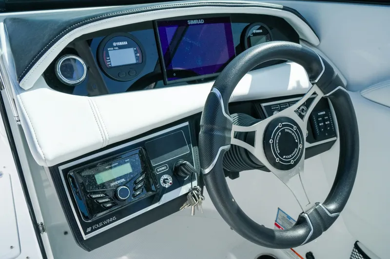 Slide: The Image of Steering console of 2026 Four Winns HD8 OB boat with modern controls and display. - 14