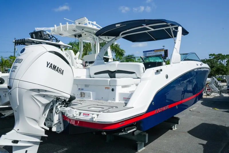 Slide: The Image of 2026 Four Winns HD8 OB boat with Yamaha outboard engine, docked under clear blue sky. - 2