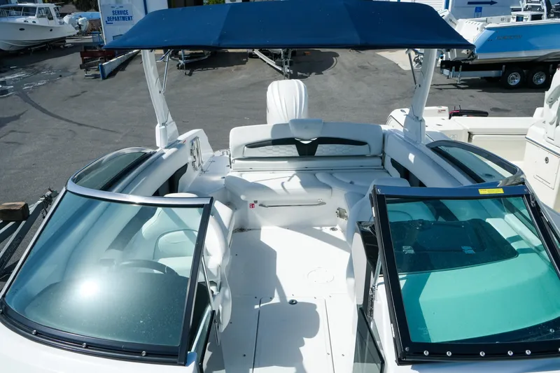 Slide: The Image of 2026 Four Winns HD8 OB boat with open cockpit and blue canopy in marina. - 20