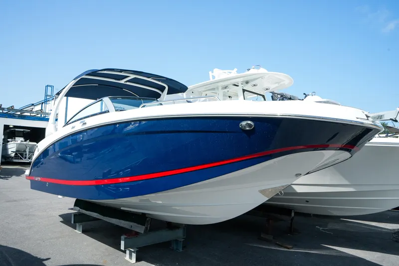 Slide: The Image of 2026 Four Winns HD8 OB boat with sleek blue and white design, docked outdoors. - 4